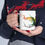 Thumbnail: Person holding mug featuring colorful bird design