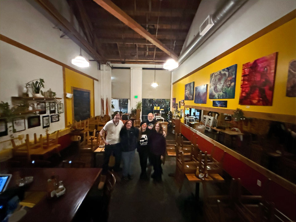 Group of happy friends in a restaurant with a new art exhibit...