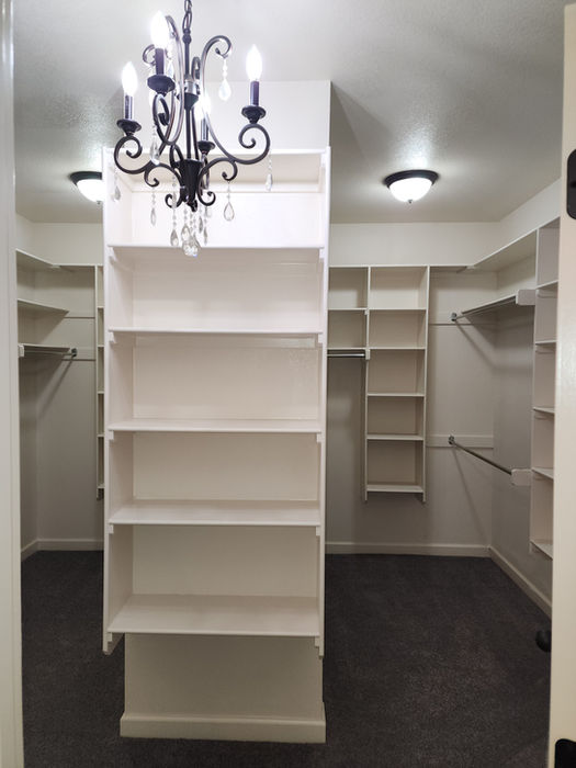 Empty walk-in closet with shelves and chandelier, ready for clothes Austin Senior Living
