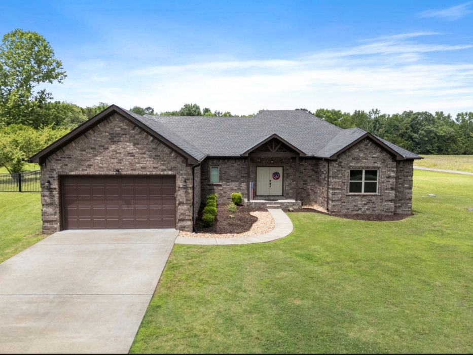 Exterior view of a brick home with a large garage door.