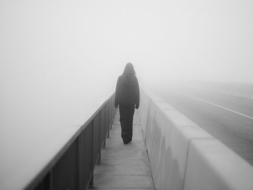 Personne marchant seule dans un brouillard dense, symbole de confusion intérieure et de dissonance cognitive.