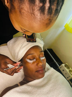 An attendant working on the eyelash of a client.