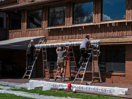 Manchester Awning crew installing a retractable patio awning on a multi-level Connecticut home