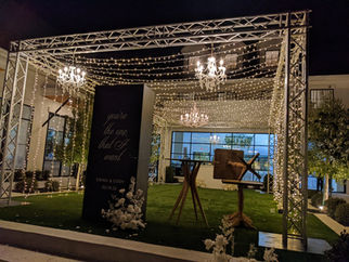 Wedding lit up with twinkle lights in a truss tunnel for guests