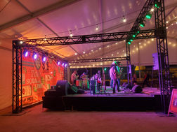 Tito's VIP tent stage with truss structure, stage lighting, and audio package. Austin Event Lighting also handled the custom branding behind the band