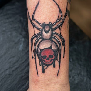 Spider tattoo with a red skull on its abdomen