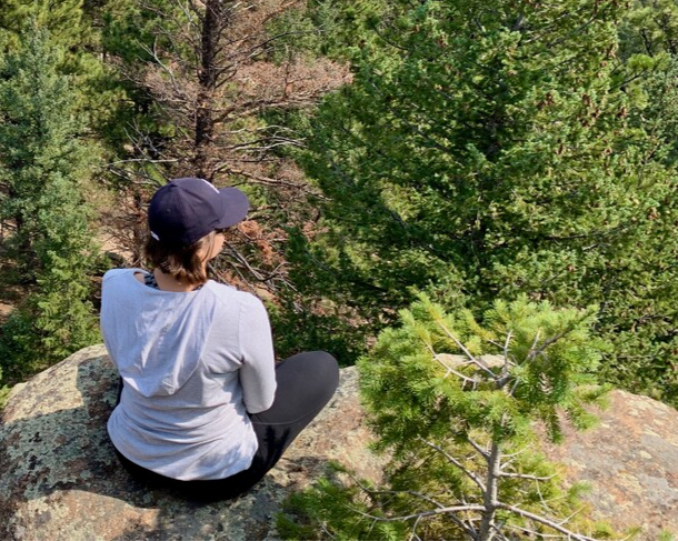 Human meditating over mountain vista