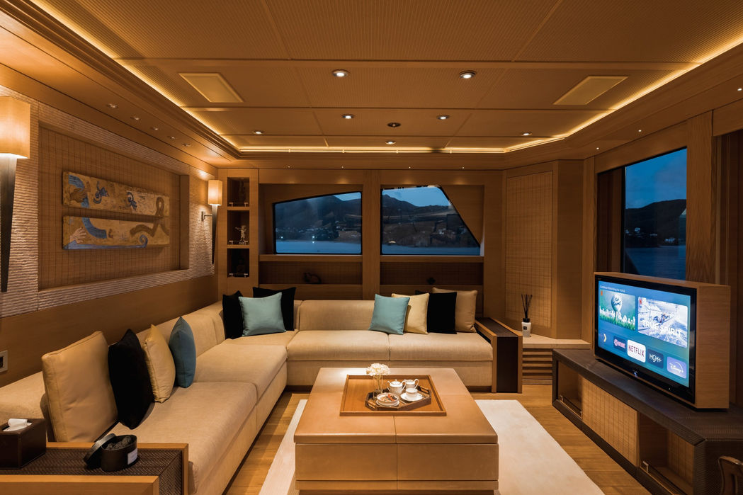 Elegant upper salon on Naia superyacht with seating and entertainment area.