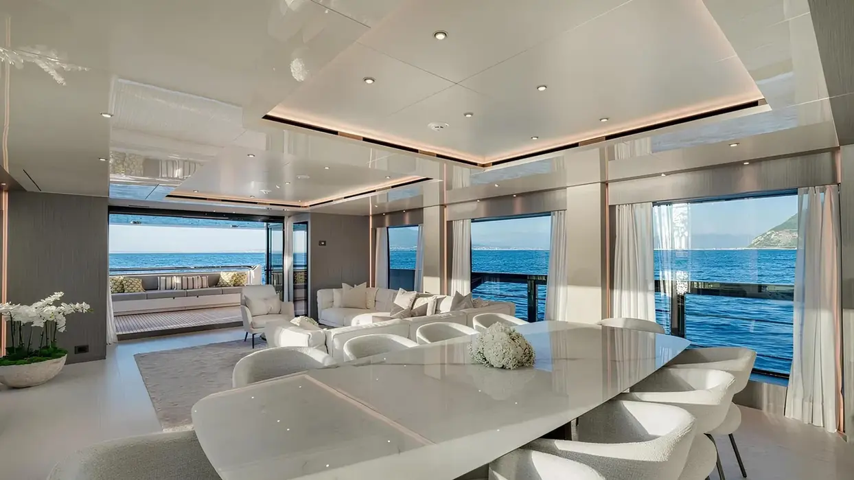 Modern salon inside Marican Forever yacht with soft seating, ample natural light, and ocean views.