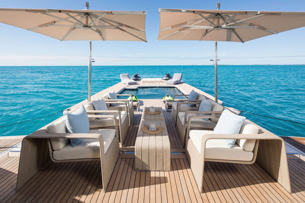 Open-air dining deck on Artisan superyacht with ocean backdrop, exclusive charter by Navélia Yacht Charter St Tropez