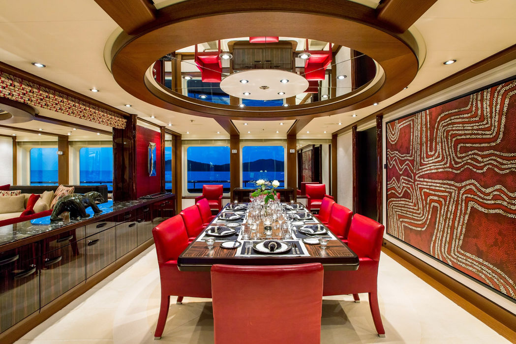 Formal dining room on Slipstream with glossy black flooring and red accents.