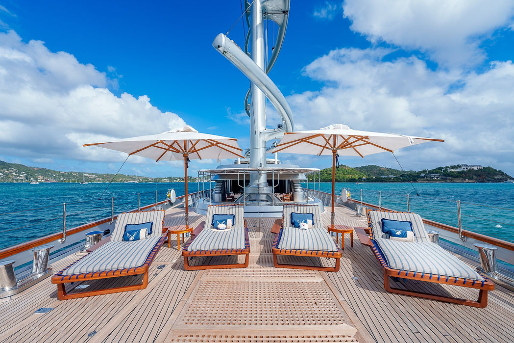 Wide bow deck aboard a sailing superyacht with multiple seating areas.