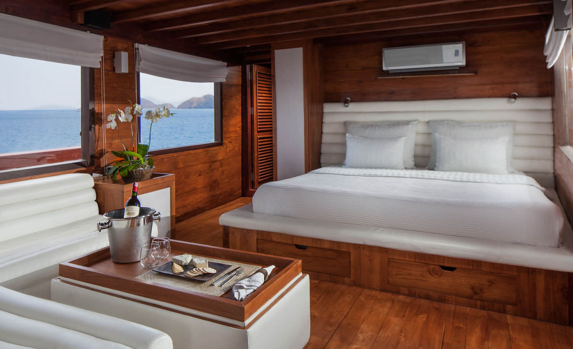 Guest cabin bed detail onboard Samata Phinisi during a Komodo yacht charter with Navélia Yacht Charters Indonesia.