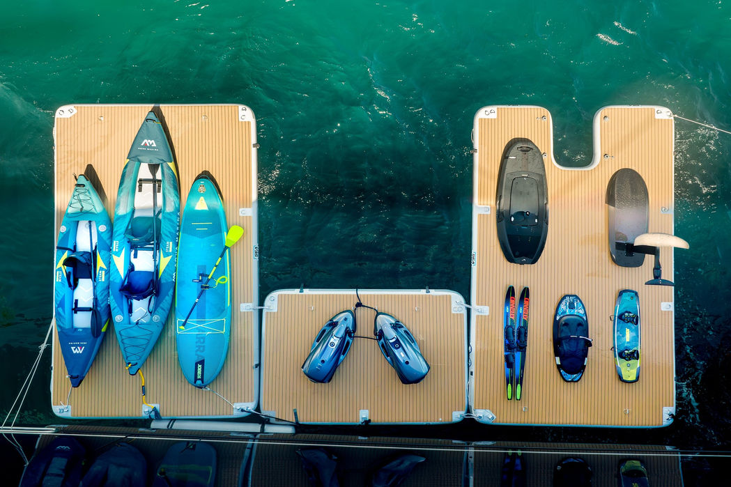 Full set of water toys including seabobs and paddleboards displayed behind the superyacht.