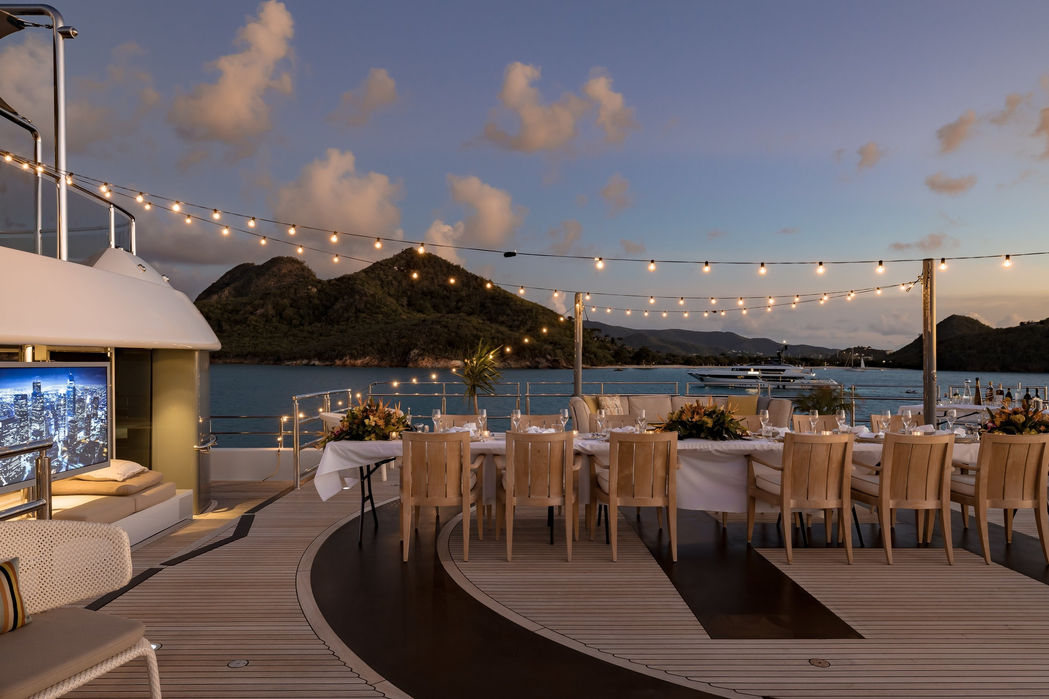 Aft deck of Naia superyacht during sunset with relaxed outdoor seating.