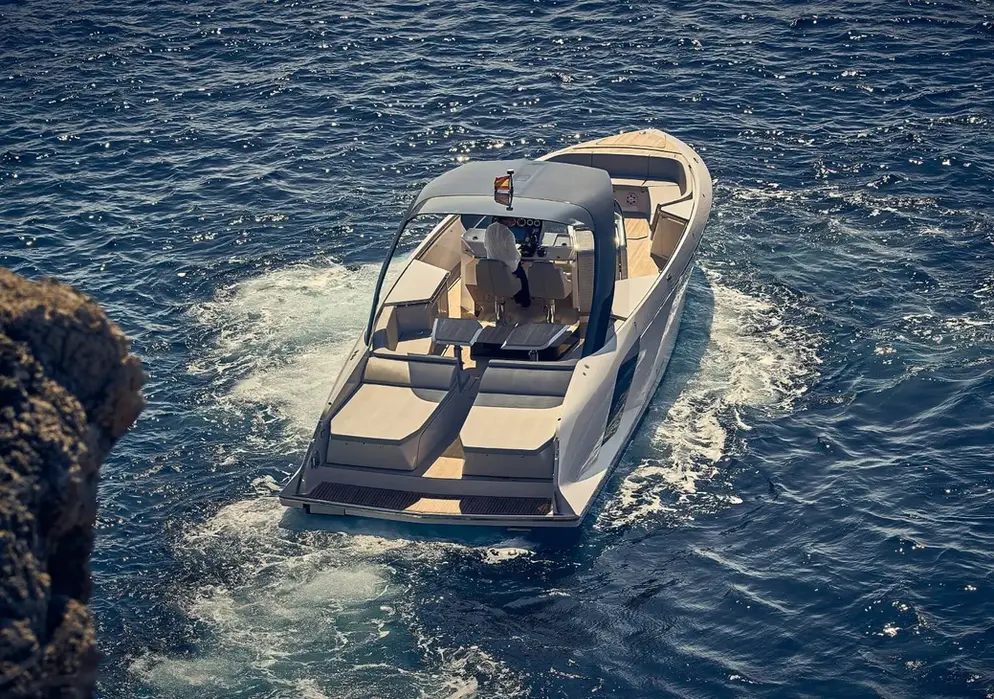 frauscher 1414 demon air approaching rocky coastline with sunpads and teak deck visible