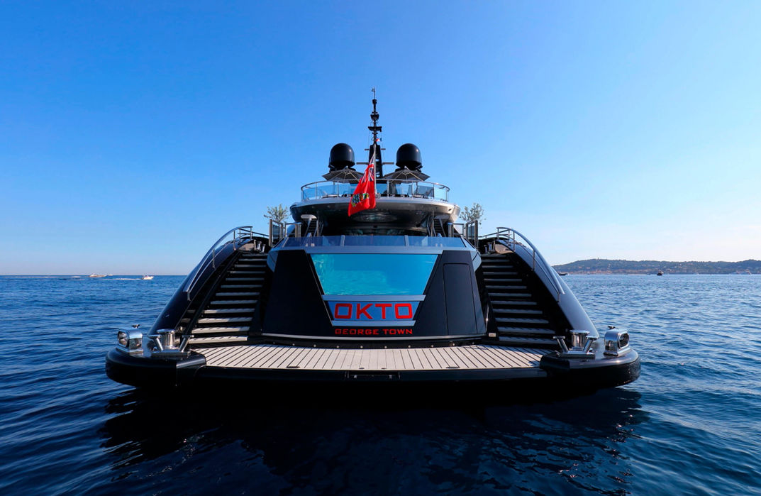 Front view of the Okto superyacht highlighting its sleek black hull design.