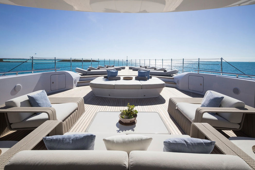 Upper deck lounge area on Artisan superyacht featuring sun loungers and open views, chartered with Navélia Yacht Charter St Tropez