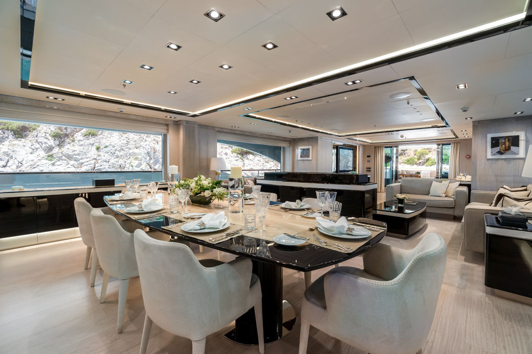 Elegant dining area onboard O’Mathilde with a large table and upscale lighting.
