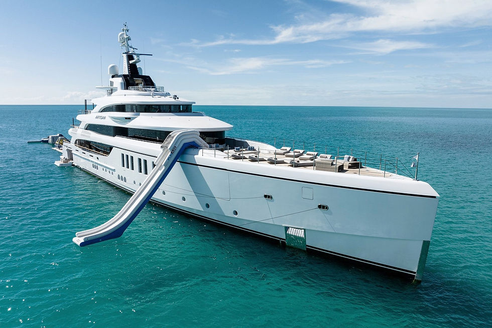 Artisan superyacht anchored at sea with aft deck sun loungers and inflatable water slide, luxury yacht charter by Navélia Yacht Charter St Tropez