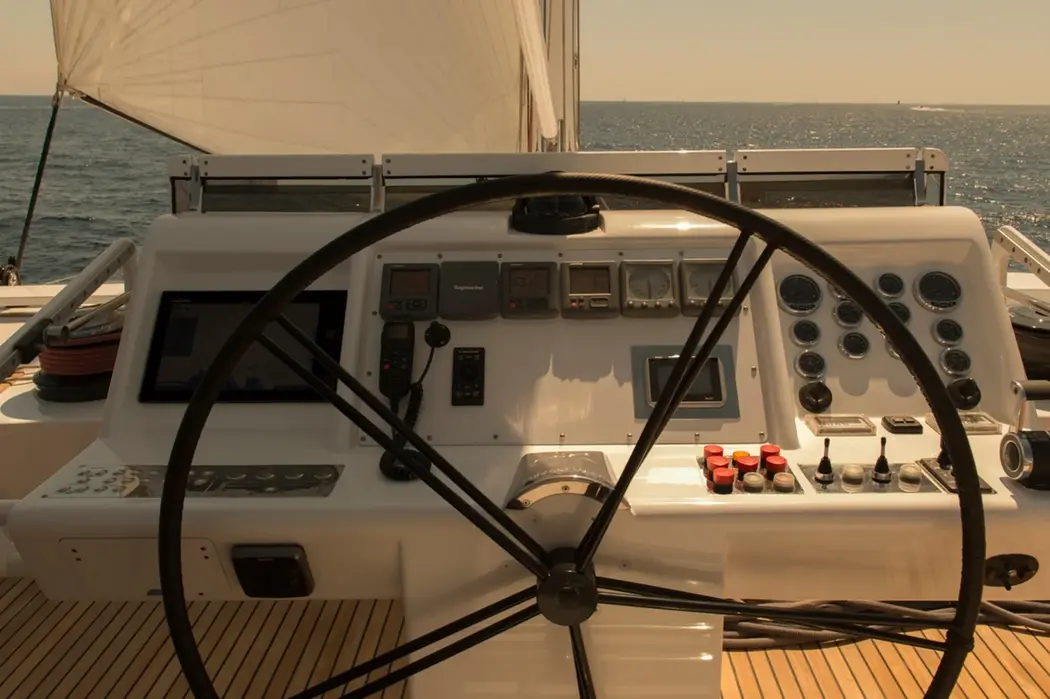 Helm controls and steering wheel inside Ipharra sailing catamaran