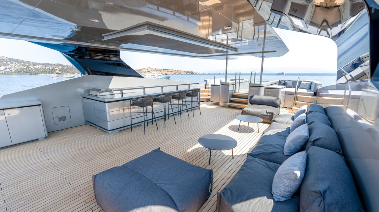 Stylish upper deck lounge with bar seating on the Provocateur superyacht, featuring panoramic Mediterranean views for relaxed cruising near Monaco.