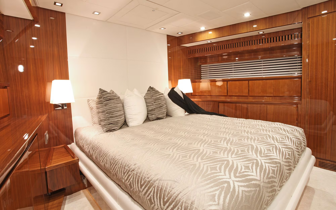 Guest cabin inside Phoenician yacht featuring warm wood finishes and soft bedding
