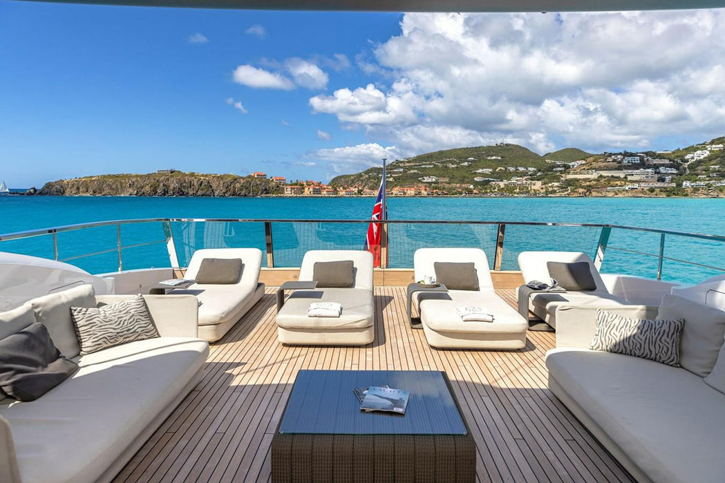 Luxury yacht Seven Sins sun deck loungers with ocean backdrop