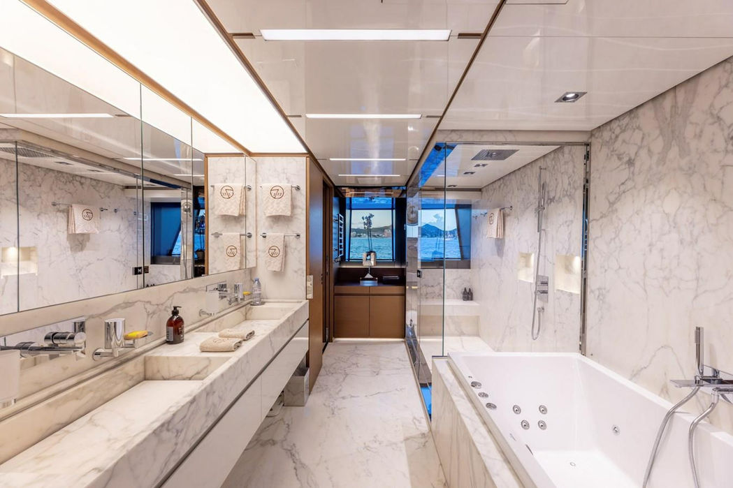 Luxury yacht Seven Sins master bathroom with marble detailing and freestanding tub