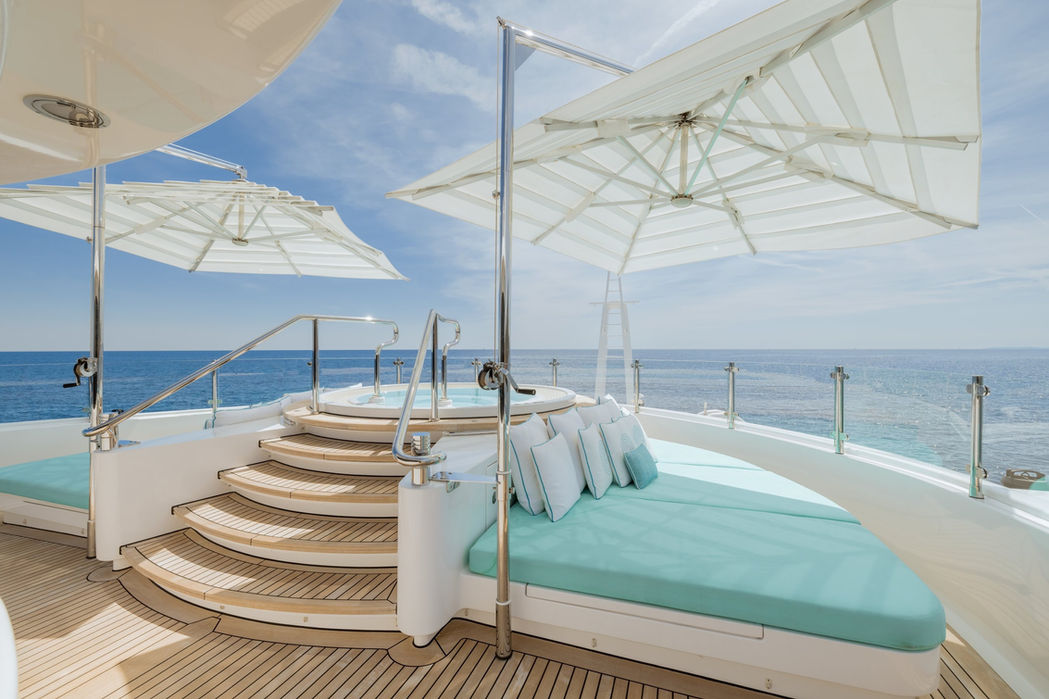 Beach club seating area on Clelia III with shaded lounge beds