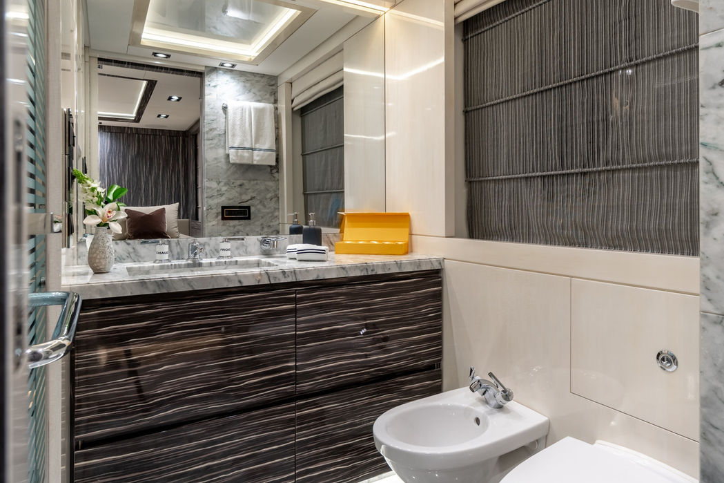 Bright bathroom on O’Mathilde featuring a marble sink, backlit mirror, and deep shower.