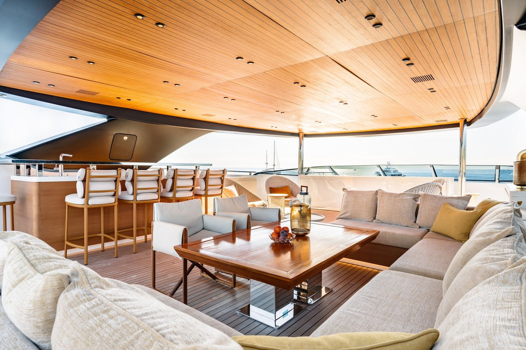 Upper saloon lounge with wood ceiling and seating onboard RMF luxury motor yacht with Navélia Yacht Charters