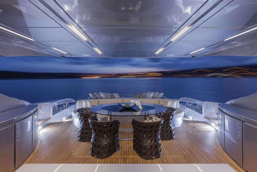 Outdoor dining setup on the Pershing 108’s aft deck overlooking the ocean.