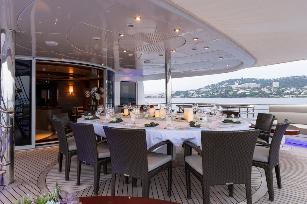 Luxury yacht Talisman Maiton upper deck alfresco dining setup overlooking the Mediterranean