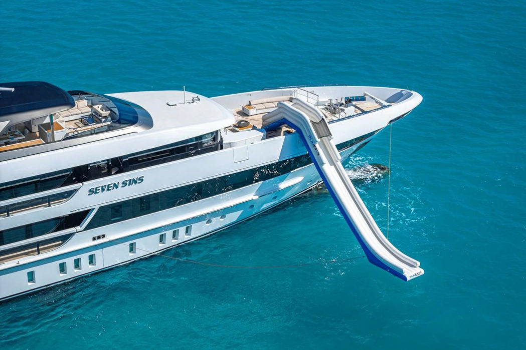Luxury yacht Seven Sins with inflatable waterslide deployed for charter guests