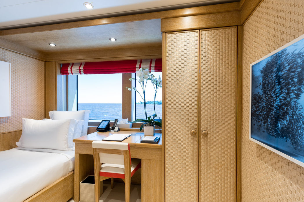 Guest stateroom on Clelia III with a cozy layout, seating area, and natural light.