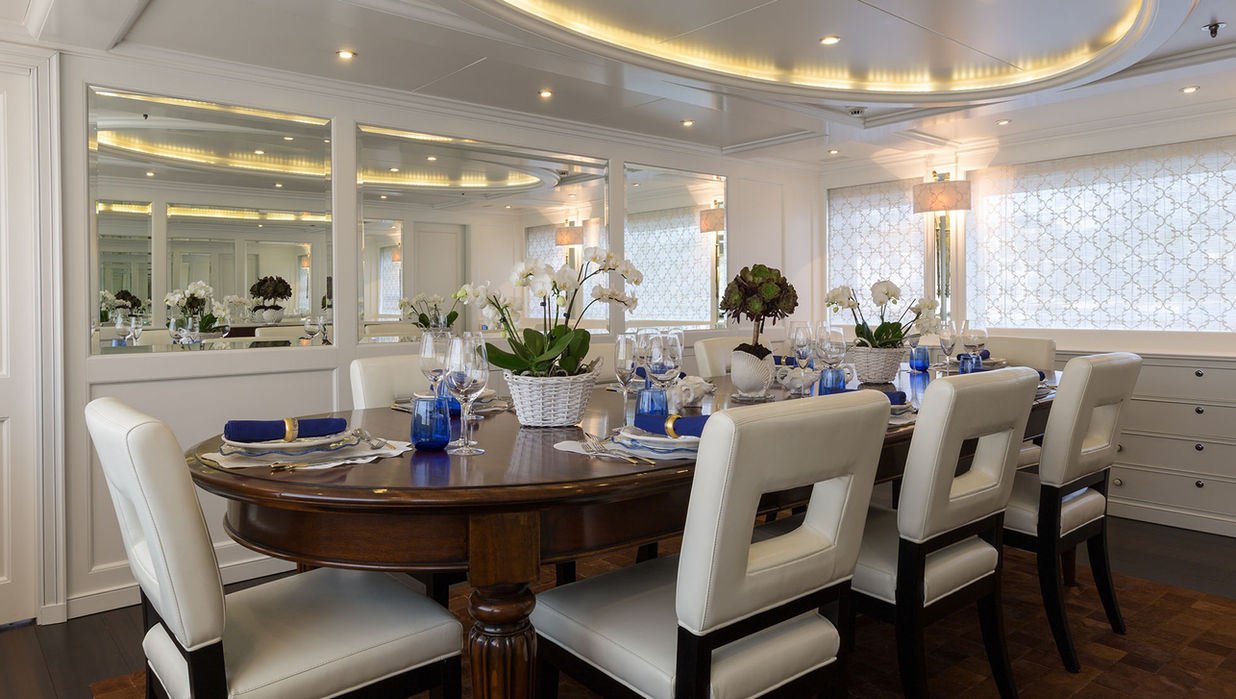 Formal dining room aboard M/Y Bina with elegant table setup for charter guests