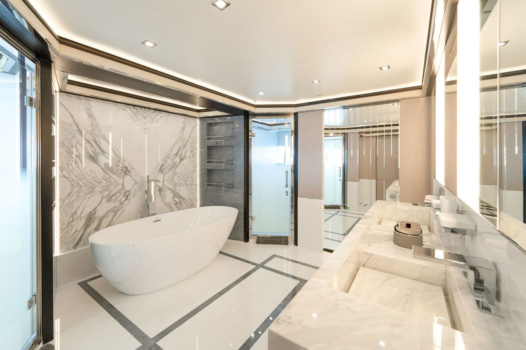 Luxurious marble master bathroom aboard the Provocateur yacht, featuring a freestanding bathtub and premium finishes.
