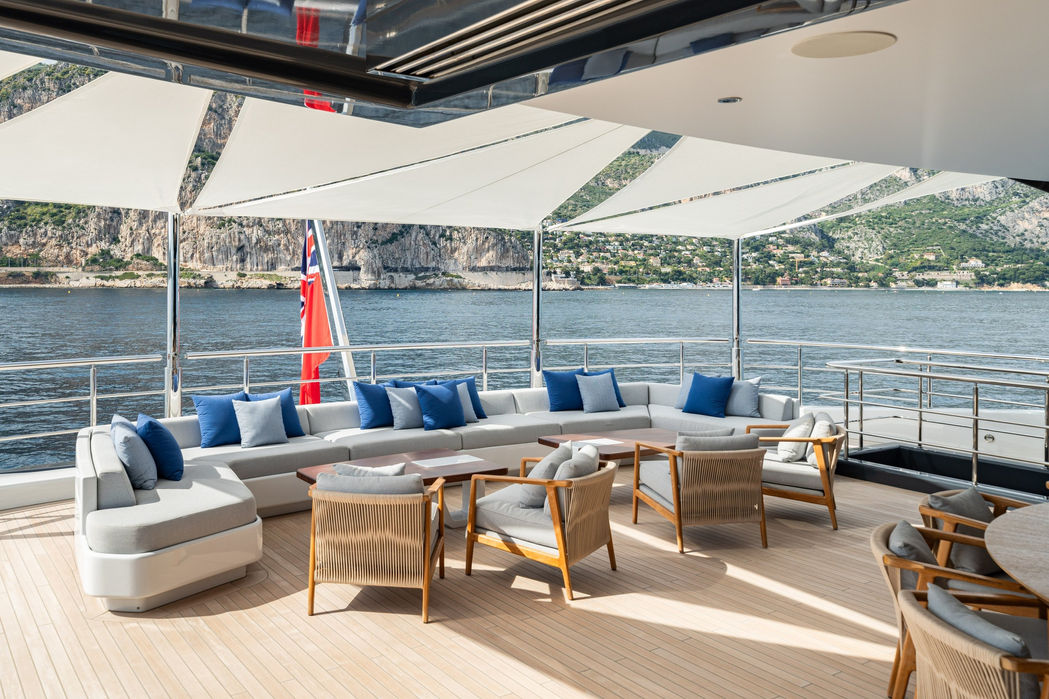 Outdoor dining table set on M/Y Malia with ocean backdrop and beautiful lighting