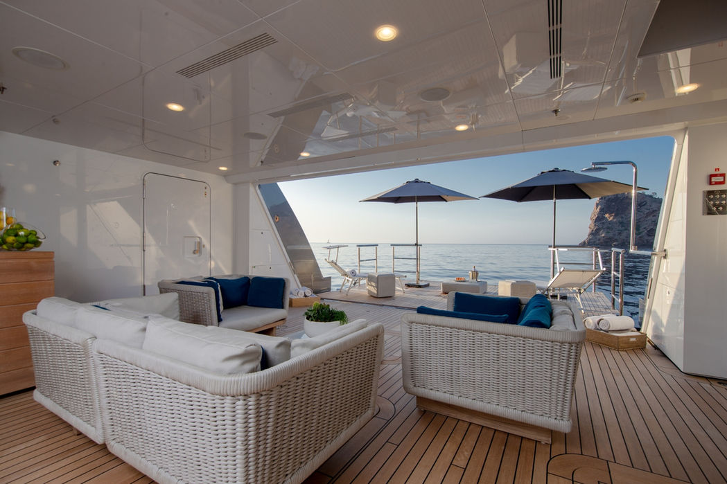 Aft deck lounge on Stella Maris superyacht ideal for socializing and sea views during a charter with Navélia Yacht Charter St Tropez