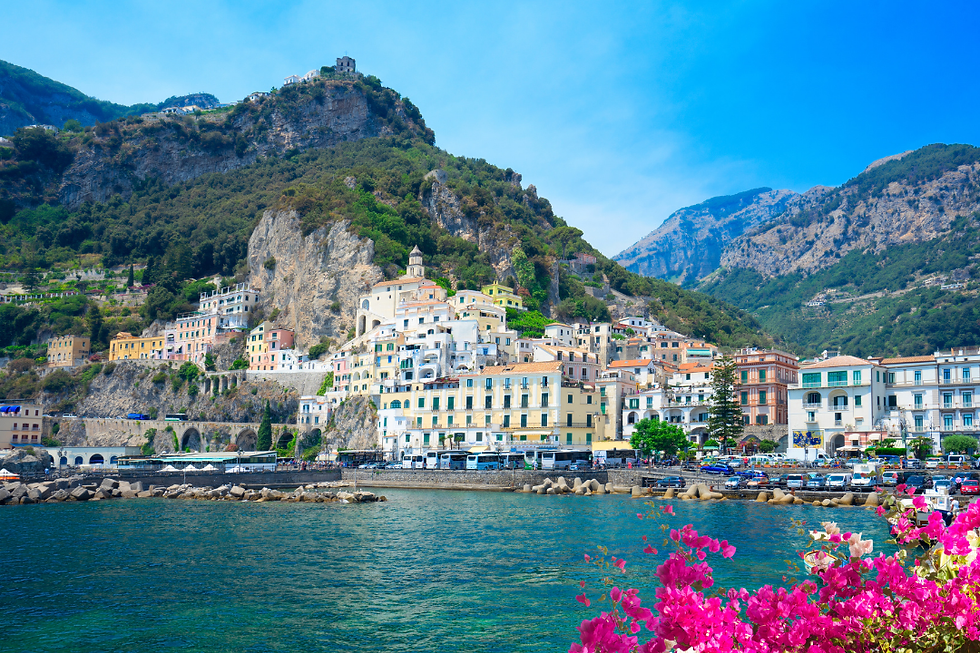 Cliffside view of Positano on the Amalfi Coast with colorful buildings cascading toward the sea and boats below