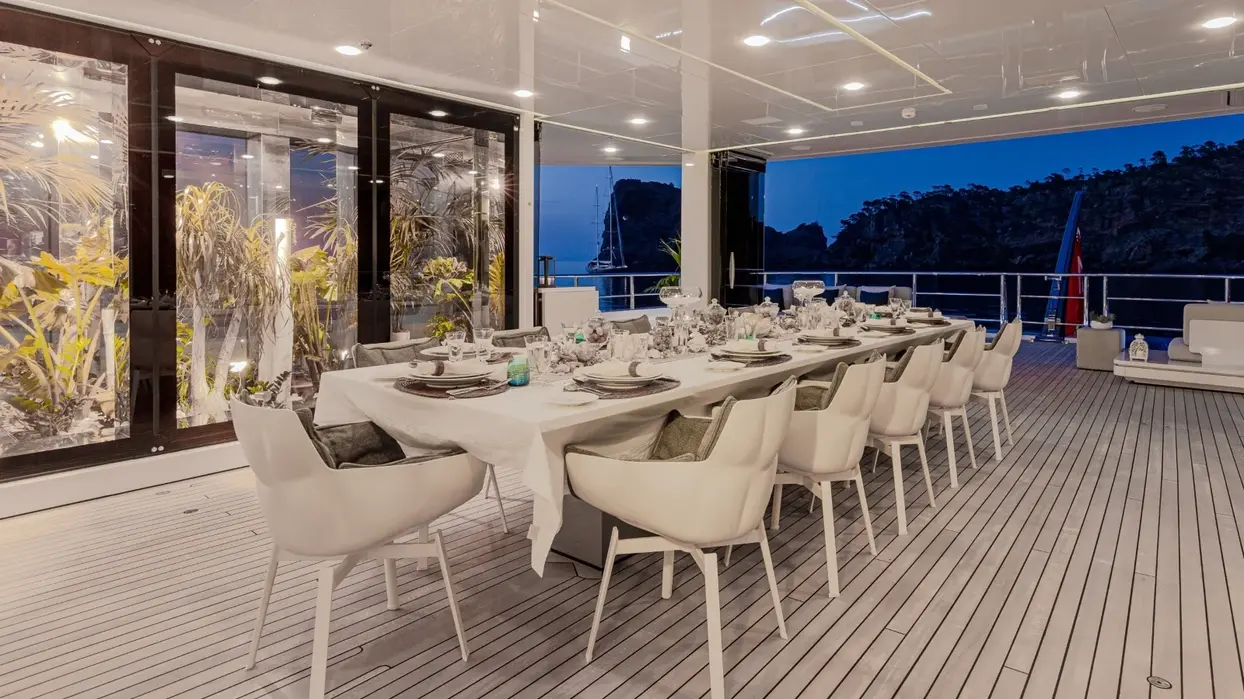 Outdoor dining setup aboard Stella Maris superyacht at sunset during a luxury yacht charter with Navélia Yacht Charter St Tropez