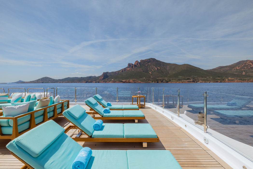 Poolside sunbeds on the sundeck of Clelia III overlooking the coastline
10