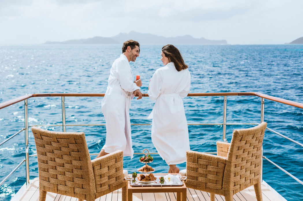 Couple enjoying a private dinner setup on the foredeck of Clelia III