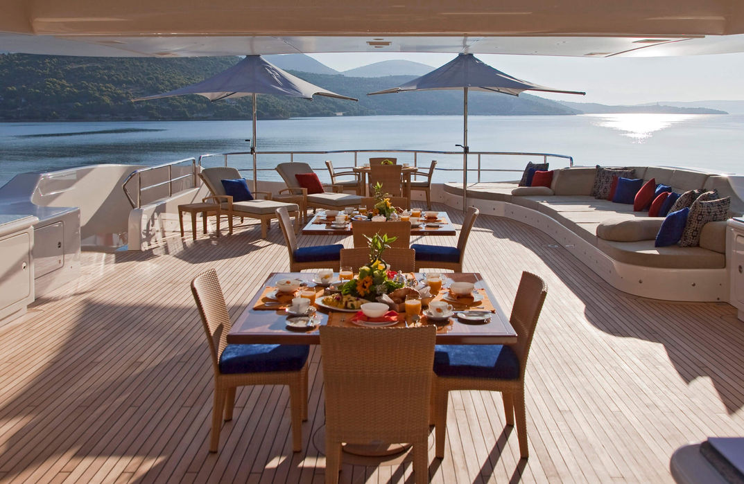 Beautiful alfresco dining area on Mary Jean II’s upper deck, perfect for relaxed meals while anchored in Monaco or Cannes.