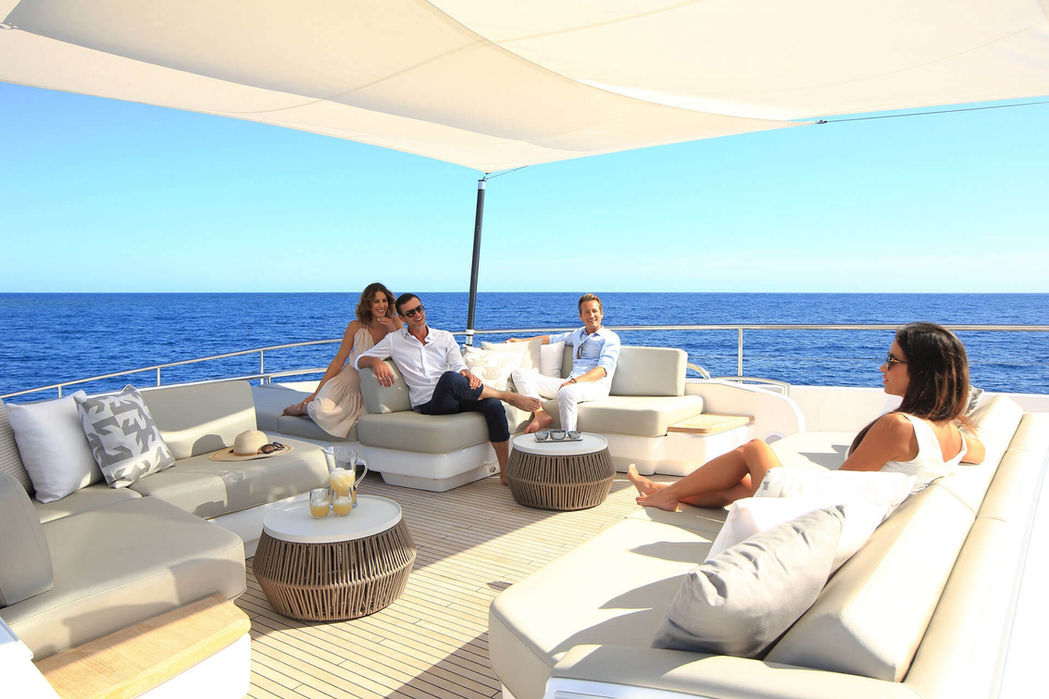 Guests enjoying alfresco dining on the Princess 35M flybridge overlooking the sea.