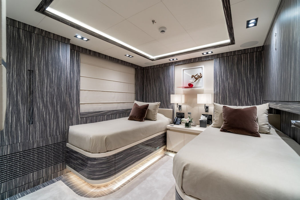 Stylish guest cabin onboard O’Mathilde featuring a neutral palette and soft lighting.