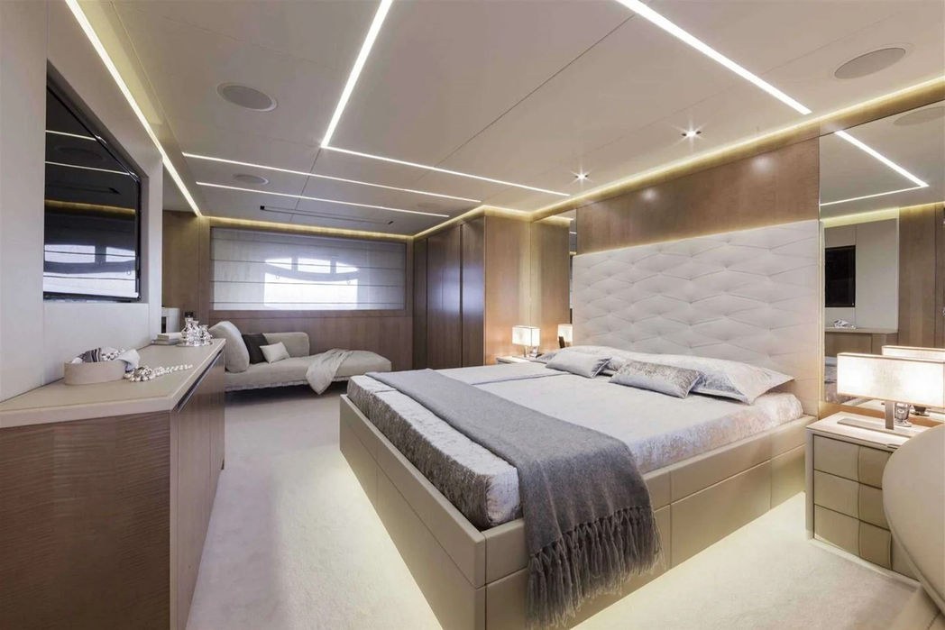 Wide-angle view of the Pershing 108 master bedroom with elegant décor and large bed.
