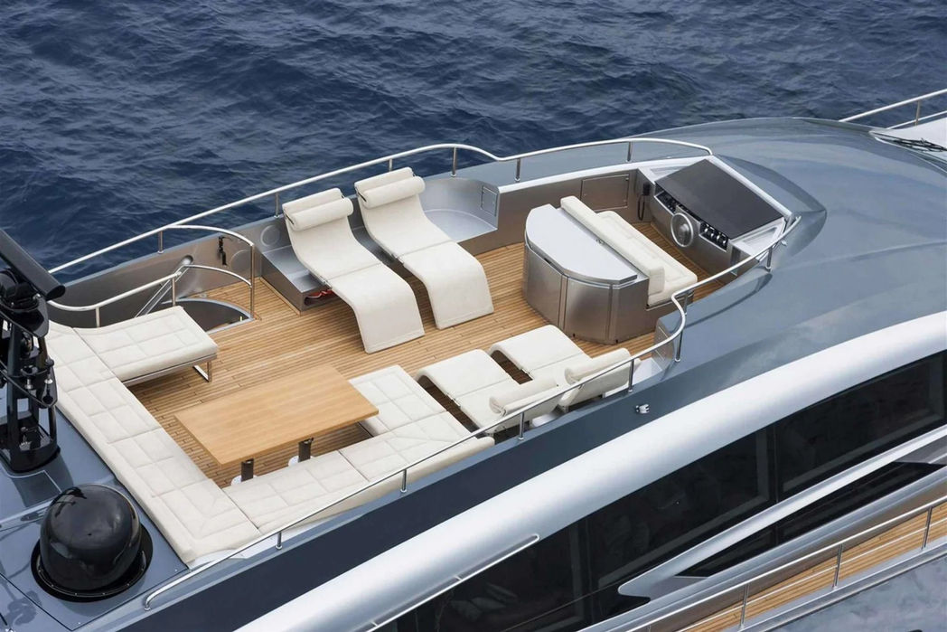 Front deck lounge of the Pershing 108 with sunpads and seating overlooking the sea.