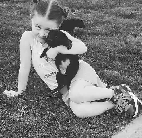 Look at this cute little lady holding an adorable puppy.